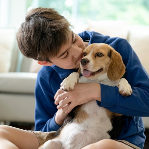 Boy cuddling dog
